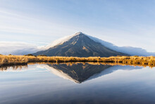 New Zealand, MountÔøΩTaranakiÔøΩvolcano Reflecting In Shiny Lake At Dawn