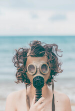 Young Woman On The Beach, Wearing Gas Mask