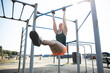 © Pete Muller/Westend61 - Female athlete doing pull ups in outdoor gym on sunny day