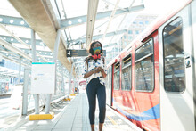 Businesswoman Wearing Face Mask Using Mobile Phone While Standing At Station Platform