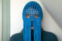 Portrait Of Young Woman Wearing Crochetedblue Headdress With Fringes