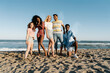 © Roger Diaz Gomez/Westend61 - Young friends standing on sand against water during sunny day