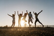 © Roger Diaz Gomez/Westend61 - Friends jumping with joy on beach during sunset