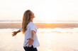 © steve brookland/Westend61 - Carefree woman with arms outstretched looking up while standing against sea
