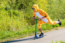 Young Man Wearing Giraffe Costume On Scooter
