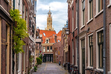 Netherlands, North Holland, Haarlem, Empty Alley Between Old Historic Houses With Tower Of Bakenesserkerk In Background