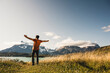 © UWE_UMSTAETTER/Westend61 - Man with arms outstretched standing at Lake Pehoe in Torres Del Paine National Park, Chile Patagonia, South America
