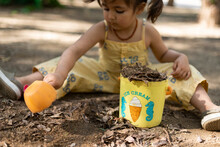 Little Girl Playing With Soil In A Park