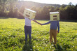 © VALENTINA BARRETO STUDIO/Westend61 - Boys face covered with box holding hands while standing on grass