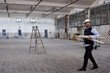 © Veam/Westend61 - Male architect with cardboards walking on floor in constructing building