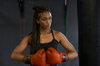© victor espadas/Westend61 - Young woman with braided hair wearing red boxing gloves in gym