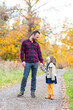 © William Perugini/Westend61 - Smiling father looking at daughter while holding hands standing in forest
