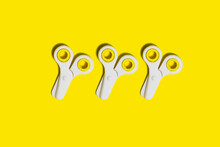 Studio Shot Of Three Pairs Of School Scissors Against Yellow Background