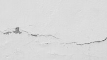 A Shot Of A Cracked White Wall Of The Building. A Worn Wall For A Construction Background Texture Collection.