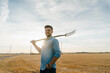 © Gustafsson/Westend61 - Portrait of smiling young man holding pitchfork standing on stubble field