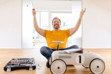 Happy Man Assembling Toy Car