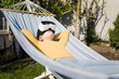 © Robijn Page/Westend61 - Girl lying in hammock in garden wearing VR glasses