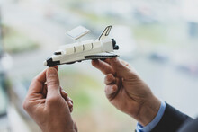 Close-up Of Bussinessman Holding Space Shuttle Model