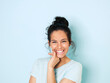 © Eichinger/Westend61 - Portrait of young woman with black hair, light blue background