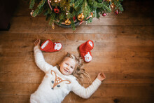 Smiling Girl Lying Under The Christmas Tree