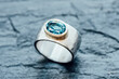 © Ina Peters/Westend61 - Silver ring with Topaz in gold setting on slate