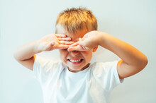 Boy Covering His Eyes In Front Of White Background