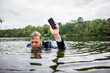 © Joseffson/Westend61 - Businessman holding cell phone inside a lake