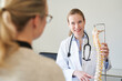 © philipp nemenz/Westend61 - Female doctor explaining spine model to patient in medical practice
