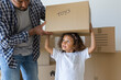 © SusPons/Westend61 - Father with daughter carrying cardboard box at new home