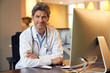 © Philipp Dimitri/Westend61 - Portrait of confident doctor at desk in his medical practice