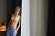 © philipp nemenz/Westend61 - Young woman standing wearing bra and pyjama pants looking down
