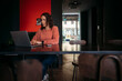 © Juri Pozzi/Westend61 - Young woman using laptop in a cafe