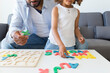 © SusPons/Westend61 - Father and daughter playing with alphabet learning game at home