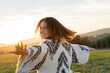 © Westend61 - Cheerful young woman dancing with arms outstretched during sunset