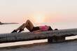© VITTA GALLERY/Westend61 - Woman relaxing on retaining wall against sea