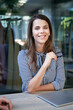 © philipp nemenz/Westend61 - Portrait of confident businesswoman at table in the city