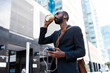 © JOSEP SURIA/Westend61 - Young businessman with earphones and smartphone drinking coffee to go  outdoors