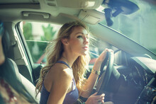 Blond Woman Looking Out While Driving With Friend During Road Trip