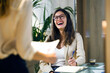 © Lifestock/Westend61 - Laughing businesswoman looking at colleague in modern office