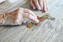 Hand Of Senior Woman Counting Coins, Close-up