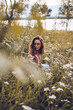© RUBEN S./Westend61 - Young woman crouching in flower meadow