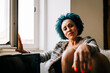 © Alexandra C. Ribeiro/Westend61 - Mid adult woman with curly hair sitting by window at home