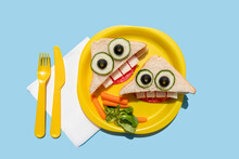 Studio Shot Of Plastic Plate With Two Funny Looking Sandwiches With Anthropomorphic Faces