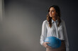 © Kniel Synnatzschke/Westend61 - Serious young businesswoman holding hard hat