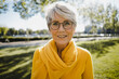 © KNSY/Westend61 - Portrait of smiling mature woman with grey hair wearing glasses and yellow clothes