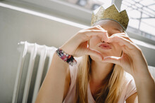Young Woman Wearing A Crown Shaping A Heart With Her Hands