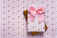 Two Wrapped Gifts Against Wrapping Paper Background