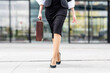 © GER/Westend61 - Young businesswoman wearing high heels walking with briefcase on footpath