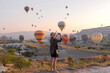 © Konstantin Trubavin/Westend61 - Young woman and hot air ballons, Goreme, Cappadocia, Turkey