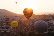 © Konstantin Trubavin/Westend61 - Colorful hot air balloons flying over rocky landscape in Goreme during sunset, Cappadocia, Turkey